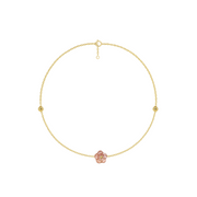 Gold anklet with a pink flower charm on a white background