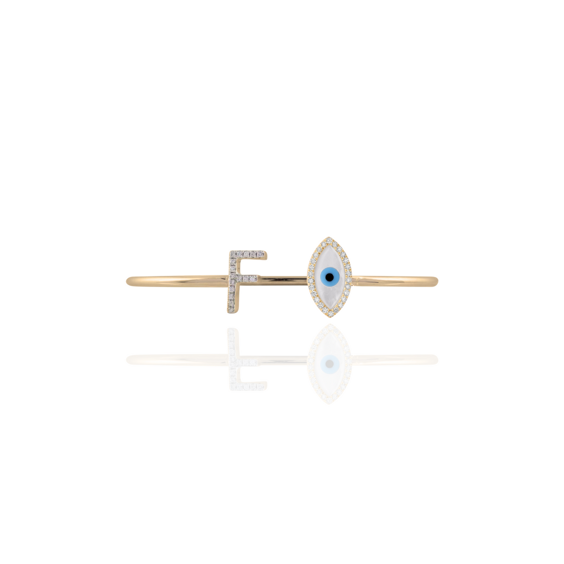 Gold bar brooch with eye design on a white background
